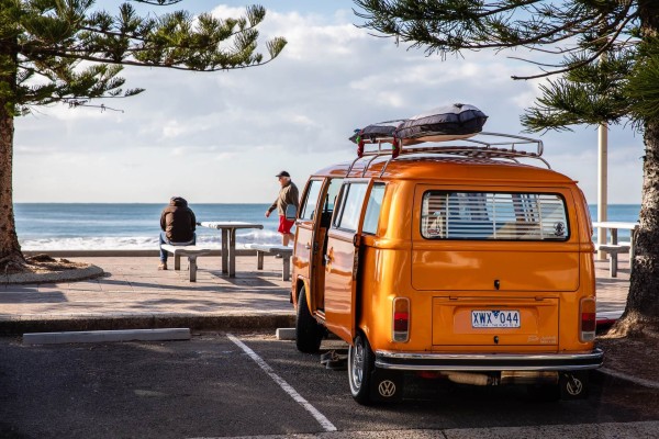 We love to surf! Our Kombi at the beach in Australia