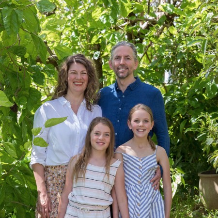 Bill and Kate outside and smiling with their children.