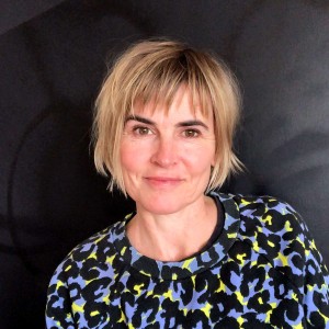 Wendy smiling, wearing a blue, black and yellow top.