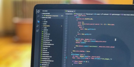 A laptop showing JavaScript code